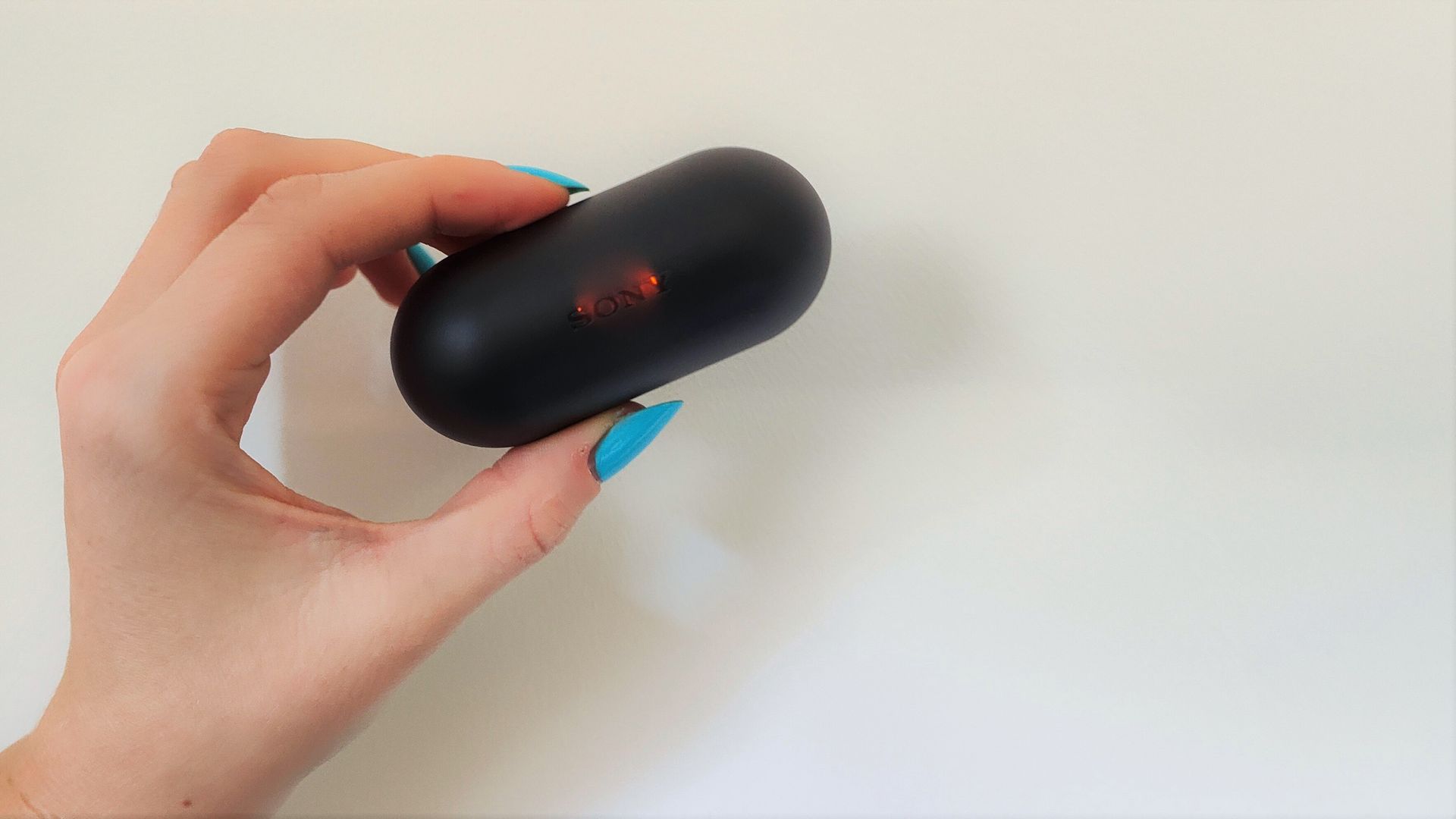 Sony WF-C500 review: black headphones case being held up