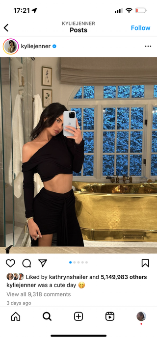An Instagram post from Kylie Jenner who is standing in a bathroom with a gold bath tub