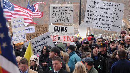 Gun rights proponents hold signs at a rally