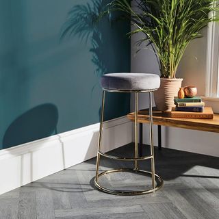 room with golden bar stool and plant in pot