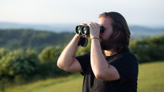 Jason Parnell-Brookes looking into the distance using the Celestron Nature DX 12x56 binoculars