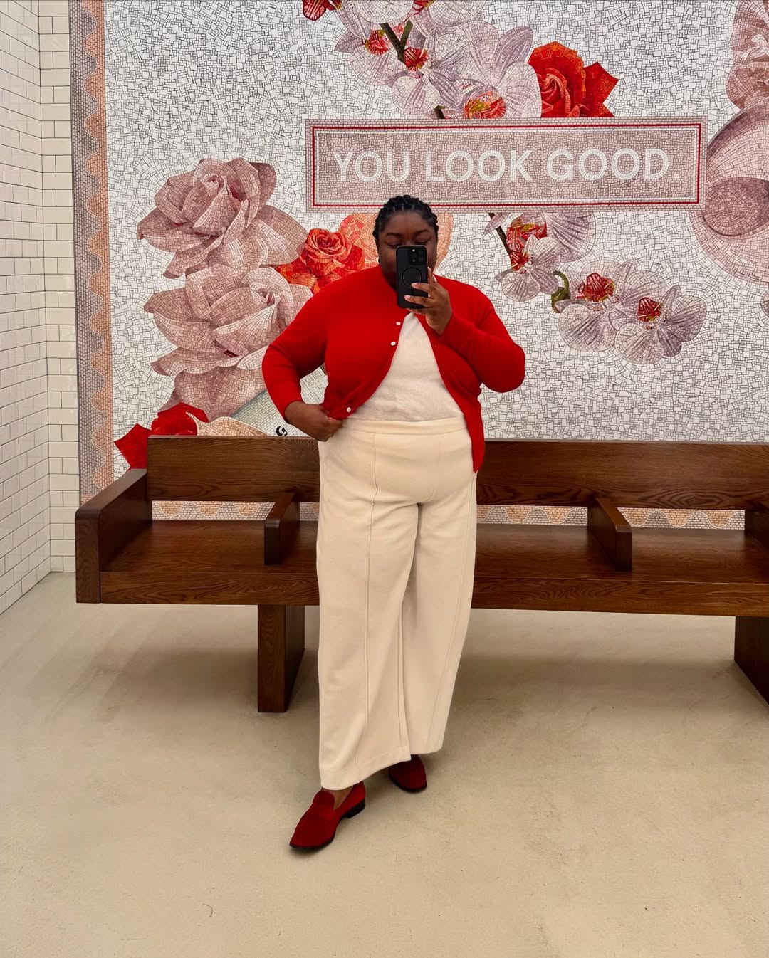 Red cardigan, cream trousers, red shoes.