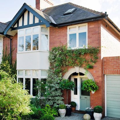 Exterior of red brick semi detached 1930s house with drive