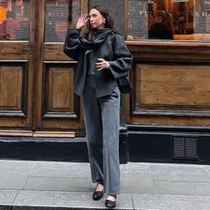 makenna wears gray pants and jacket with scarf and black shoes