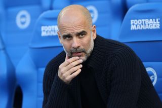 Manchester City manager Pep Guardiola sits on the bench at Brighton&#039;s Amex Stadium, May 2023