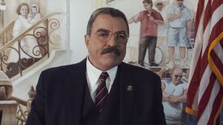 Frank Reagan standing in front of flag and wall mural in Blue Bloods Season 13