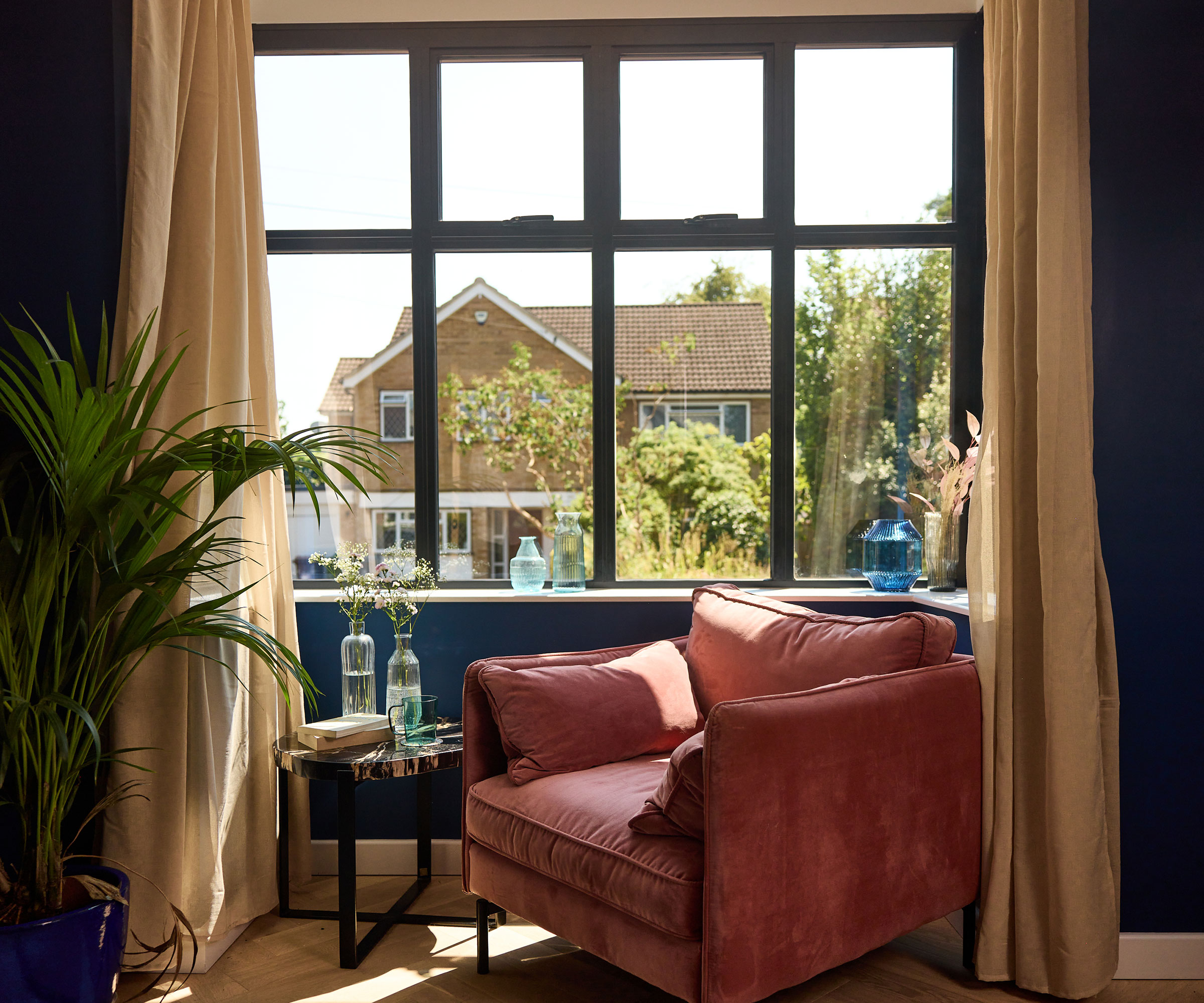living room with pink armchair in front of a large aluminium-framed window