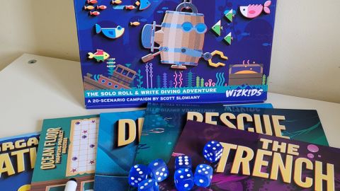 The box, dice, and scenarios of Bargain Basement Bathysphere on a white table