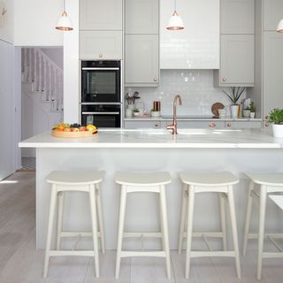 kitchen with counter and white stools pastel cupboards