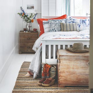 A bedroom with a white bed and boho style