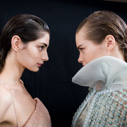 two models facing each other with glowing skin