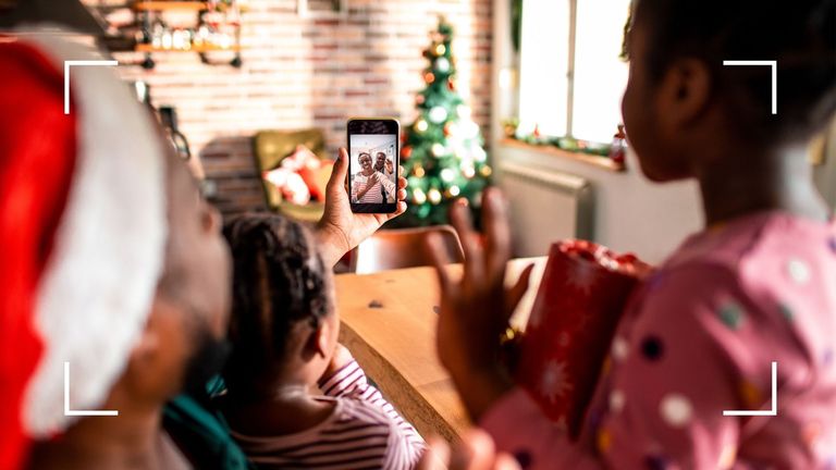 Dad and daughters on video call to family at Christmas