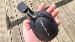 Hero image for best audiophile headphones showing Bowers & Wilkins PX7 S2 close up headphones held in hand of reviewer
