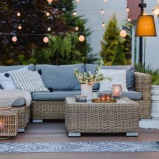 Summer evening on the patio of beautiful suburban house with garden showing layered lighting