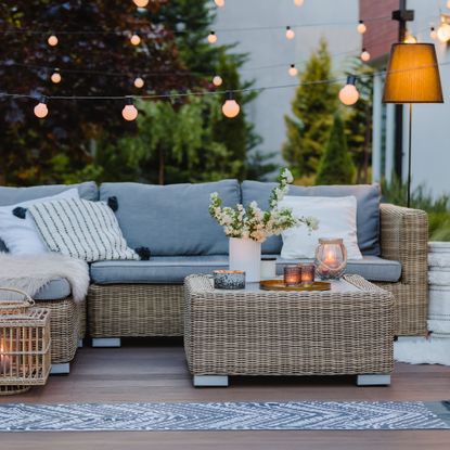 Summer evening on the patio of beautiful suburban house with garden showing layered lighting