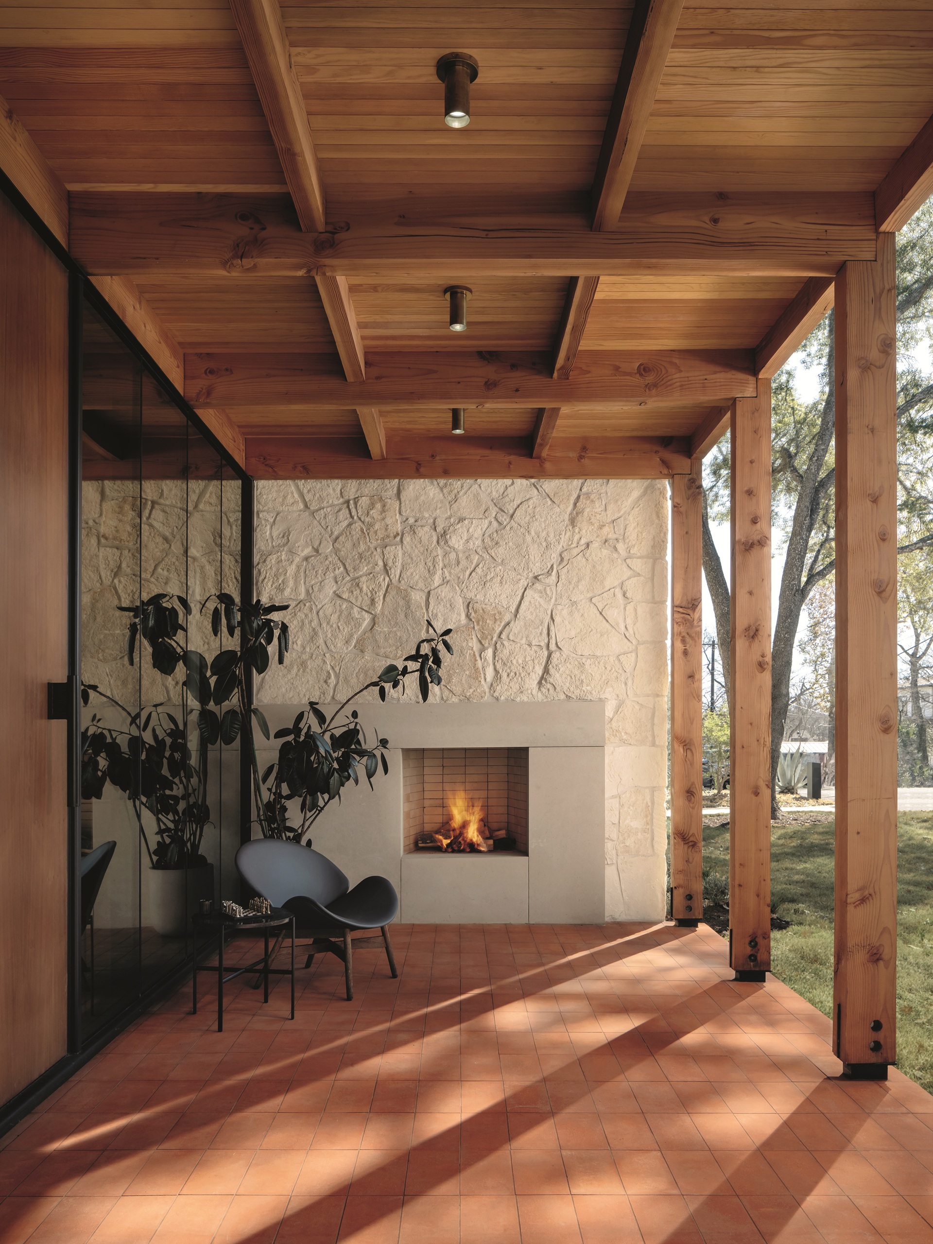 an exterior fireplace under a wood porch