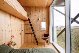 timber clad bedroom with storage mezzanine