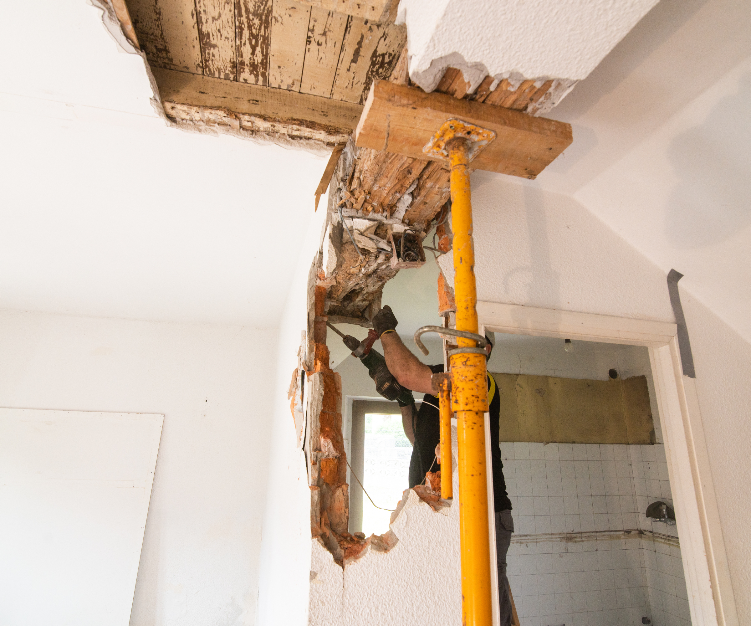 Knocking down a brick wall in a house showing acrow support in place
