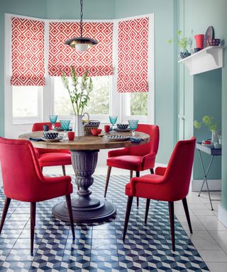 Dining room with red chairs and teal walls