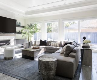 Living room light gray sectional, coffee, side and console tables, and charcoal gray rug