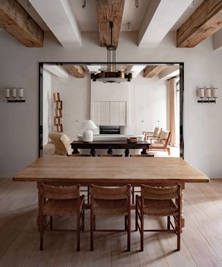 Open-plan living-dining area, wooden flooring, wooden dining table and chairs, wooden beams, view looking out into living room