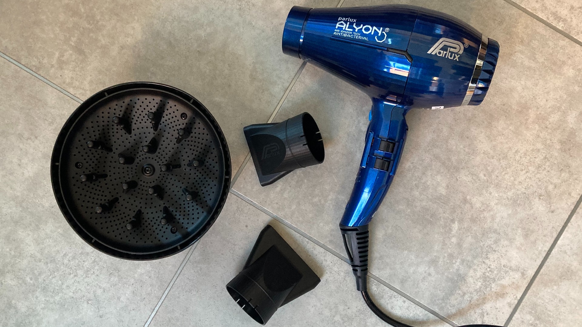 Bird's eye view of the Parlux Alyon hair dryer with two concentrator nozzle attachments and a diffuser