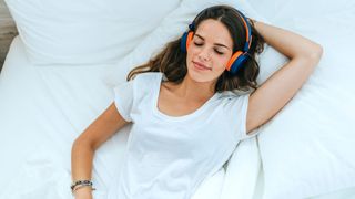Sleeping woman with headphones listening to sleep stories
