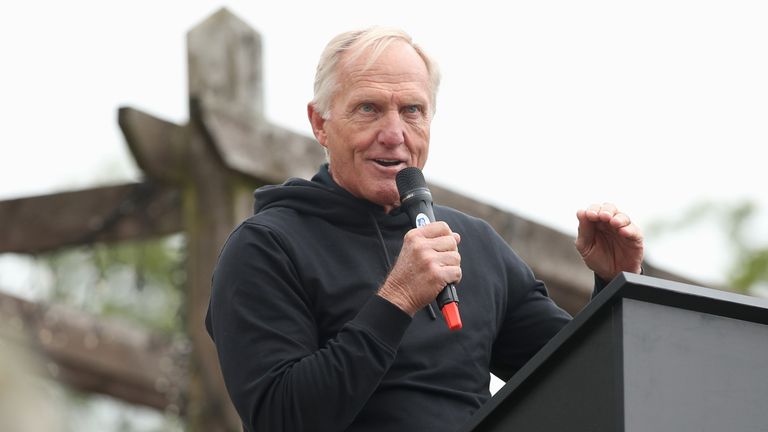 Greg Norman speaks at a microphone