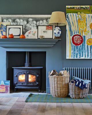 lit stove in fireplace in extension with grey walls to converted cow barn home