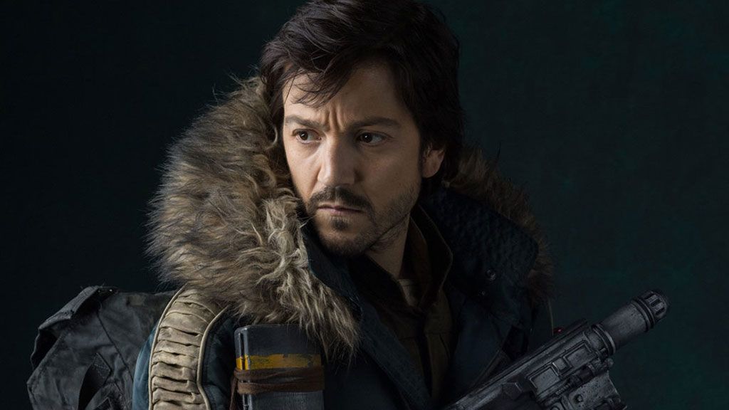 Diego Luna&#039;s Cassian Andor looks behind himself, with gun primed for action, in Star Wars: Rogue One