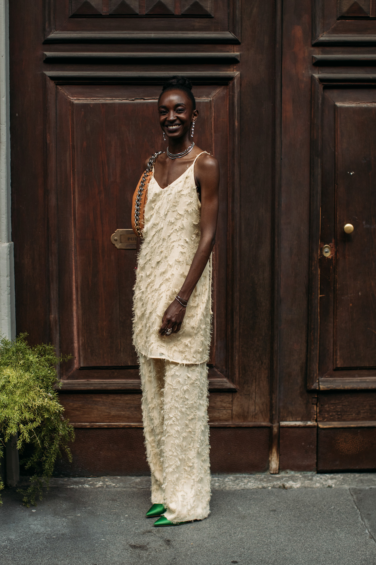 Menswear SS26 showgoer wears a textured butter yellow two-piece with apple green satin shoes in Milan.