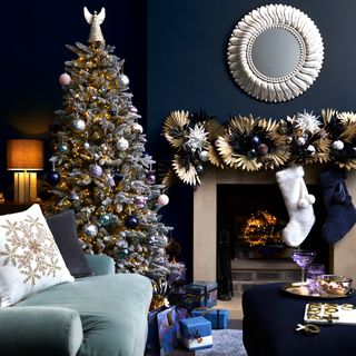 A blue-painted living room with a decorated frosted Christmas tree
