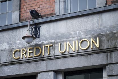 Credit union sign on dark grey stone wall