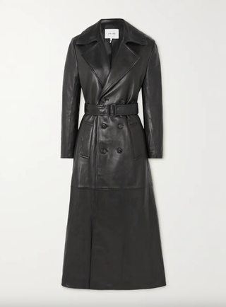 a black trench coat in front of a plain backdrop