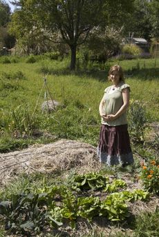 Pregnant Woman Standing In The Garden