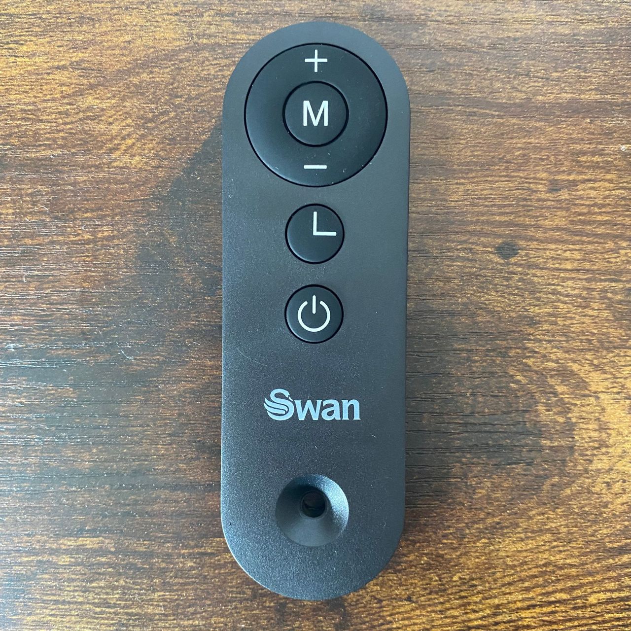 Remote control of the Swan 1.5kW Retro Ceramic Heater on a wood-look surface