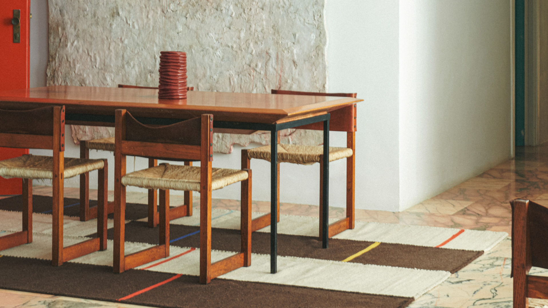 coil vase on steel-frame table set with wooden chairs from Collagerie and Zara Home collection