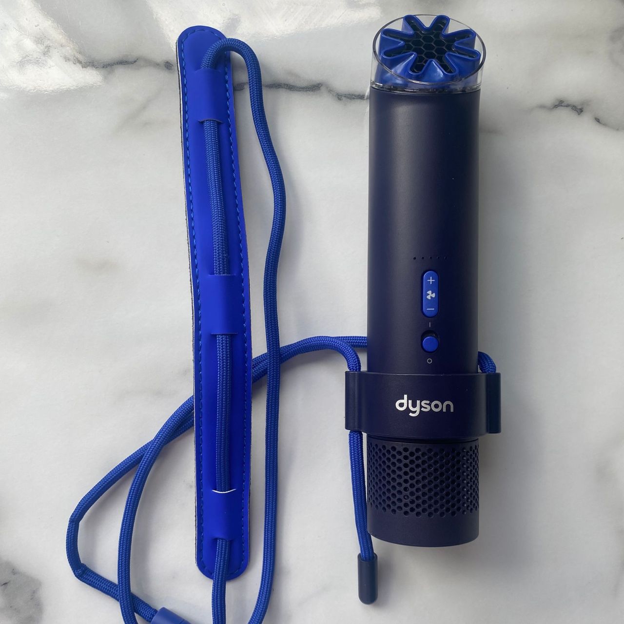 Dyson HushJet Mini Cool fan attached to the neck dock on a marble look worktop