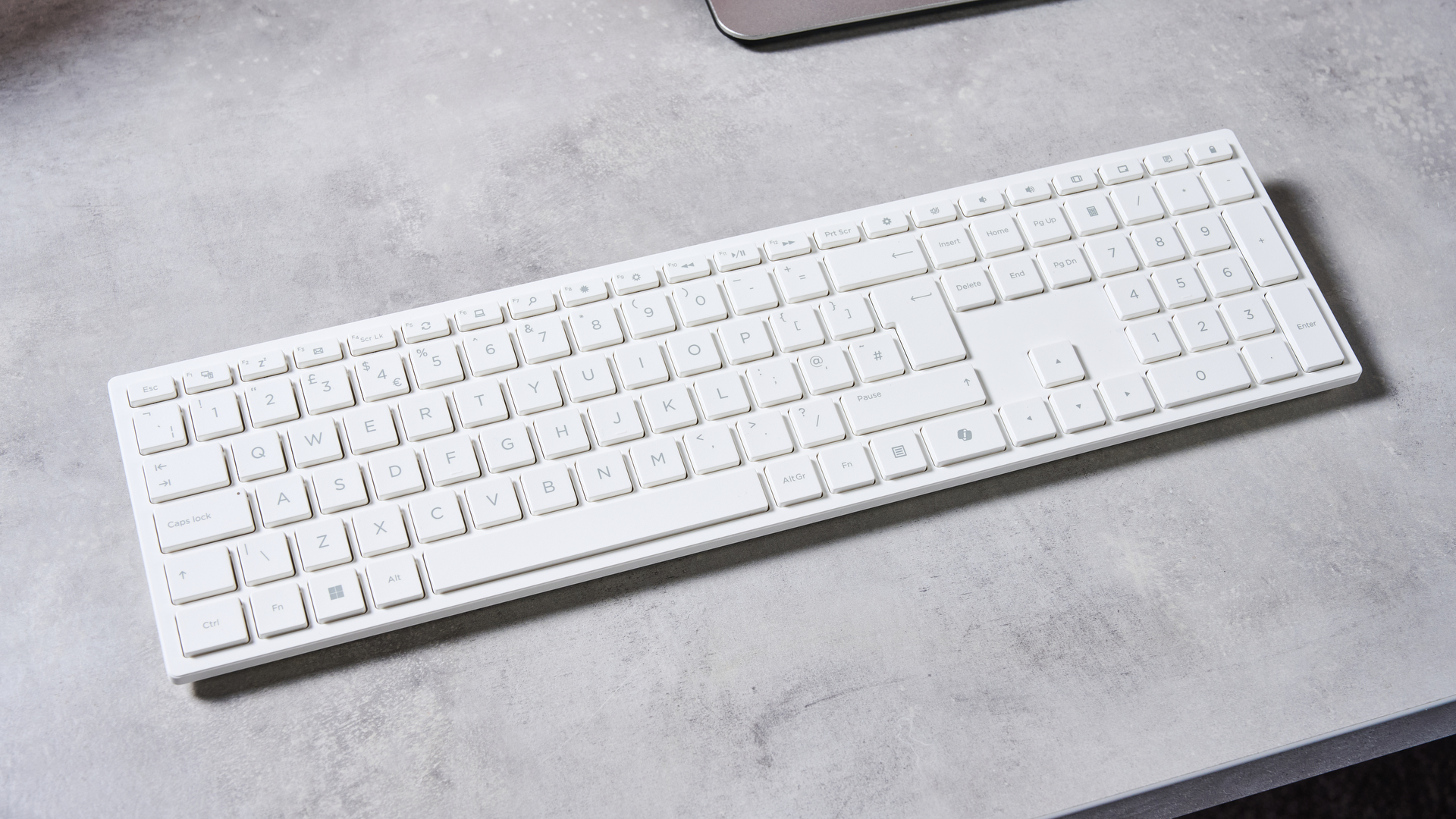 Close-up of keyboard included with Acer Aspire C24, on a grey desk