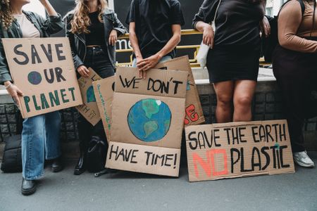 Climate activists hold signs.