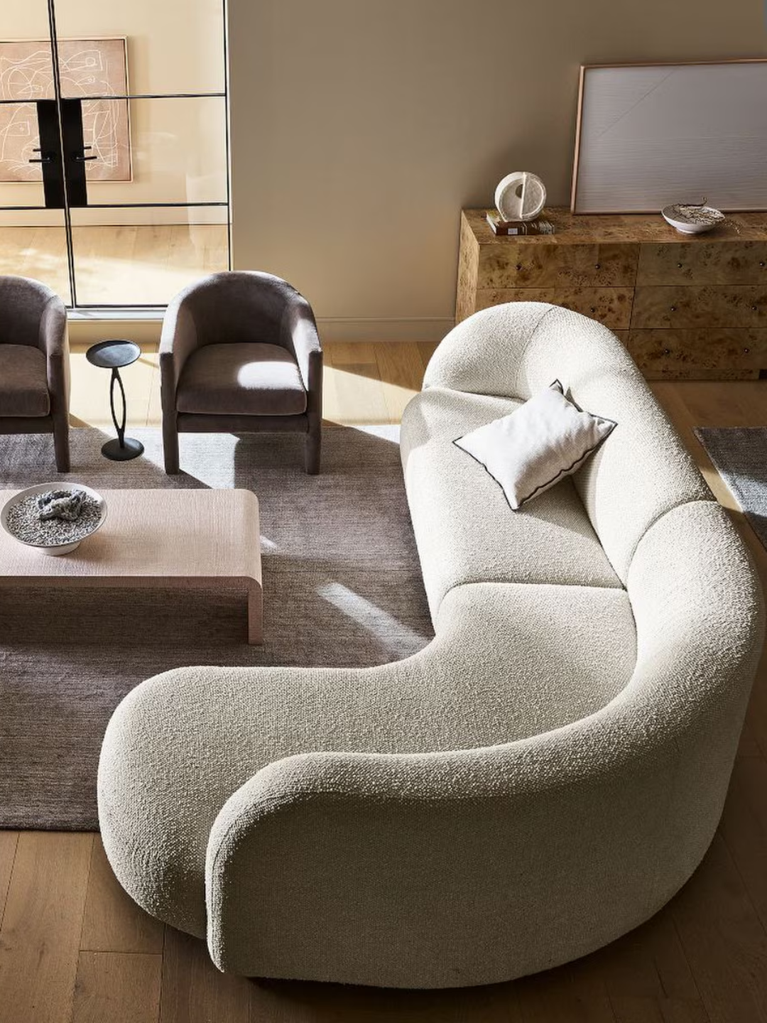 A wedge chaise sofa from West Elm with a textured off-white fabric