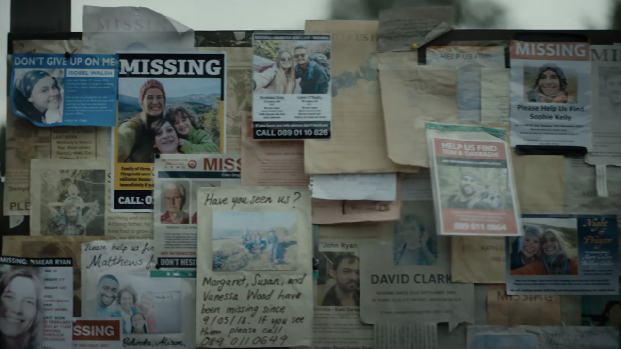 A bulletin board filled with missing posters and messages about missing families in The Watchers