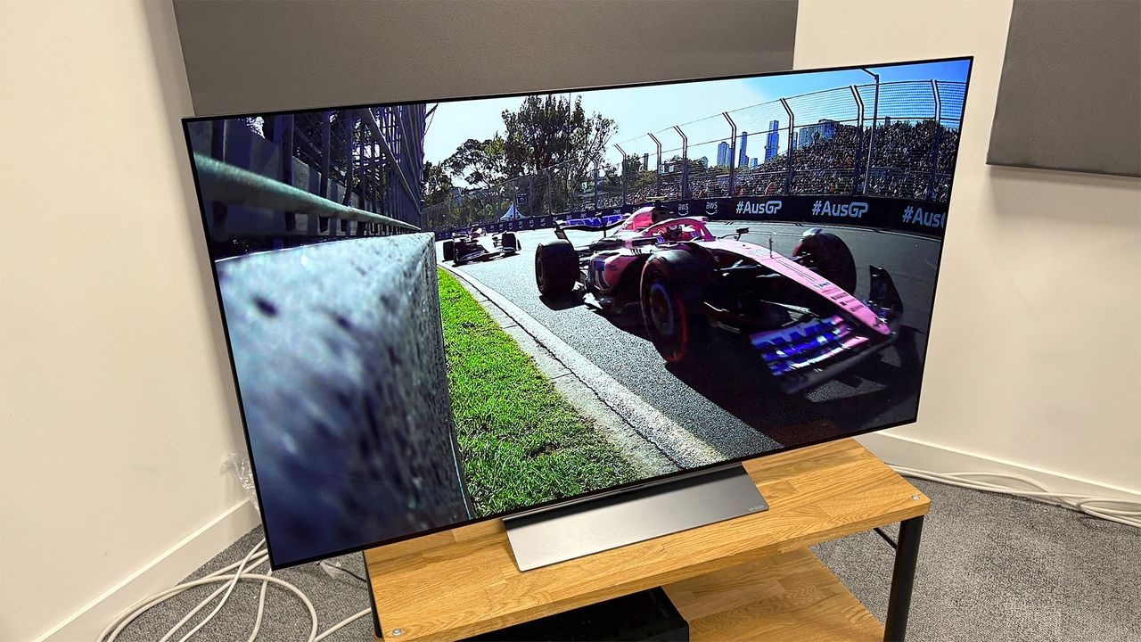 The LG C5 55-inch OLED TV on a table, seen from a slight angle to the left. On screen is a still from Netflix's Drive To Survive.