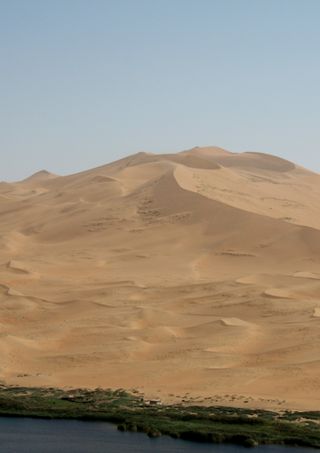 Giant dune near a lake in the Badain Jaran Desert in Inner Mongolia, China.