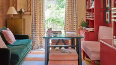 eclectic colorful living room with green velvet sofa, red gloss media wall storage with a striped sofa and green table with polka dot curtains