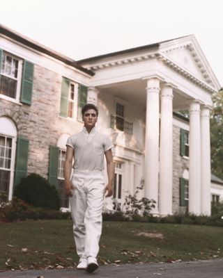 Elvis Presley wears all white as he stands outside his property on the Graceland estate in circa 1957