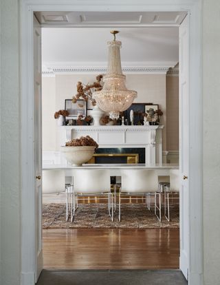 A dining room with a mantel decorated in fall flowers