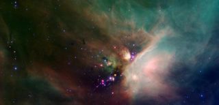 Newborn stars peek out from beneath a blanket of dust in this image of the Rho Ophiuchi dark cloud from NASA's Spitzer Space Telescope. The scope observes infrared light, which in most cases penetrates gas and dust clouds better than visible wavelengths do.