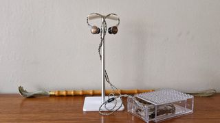 FiiO FP3 wired earbuds hanging off the top of a metallic stand