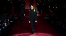 Dolce & Gabbana at Milan Fashion Week Men’s A/W 2025 featuring model in black suit on a red runway